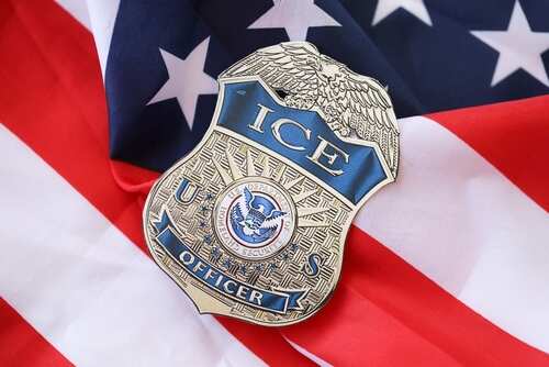 ICE officer badge resting on an American flag
