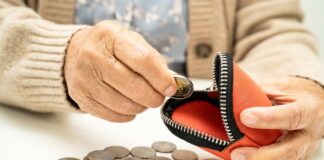 Elderly person placing a coin into a red coin purse