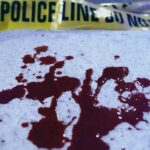 Blood stains on a surface with police caution tape in the background