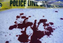 Blood stains on a surface with police caution tape in the background