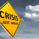 A yellow warning sign indicating a crisis ahead
