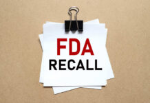A notice labeled 'FDA RECALL' clipped to white papers on a brown background