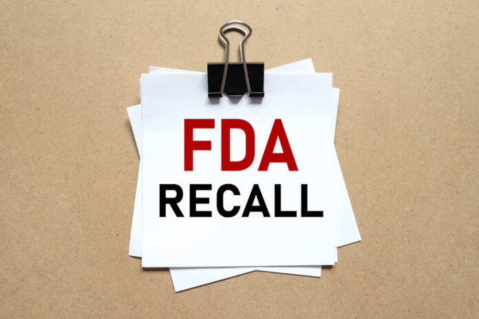 A notice labeled 'FDA RECALL' clipped to white papers on a brown background
