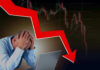 Man stressed over falling stock market graph.