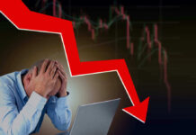 Man stressed over falling stock market graph.