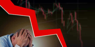 Man stressed over falling stock market graph.
