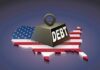A heavy weight labeled 'DEBT' sits on a map of the United States, symbolizing economic challenges.