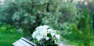 A casket adorned with white flowers in a natural setting