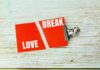 Two red cards with the words 'LOVE' and 'BREAK' separated by a clip