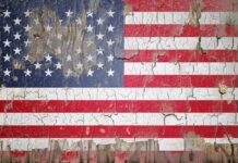 Weathered American flag with cracked paint on wood