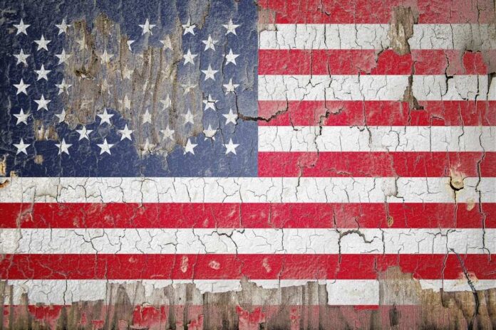 Weathered American flag with cracked paint on wood