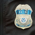 Close-up of an ICE officer badge on a black jacket