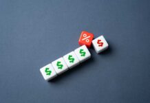 White dice with dollar signs and a red dice with a percentage symbol on a gray background