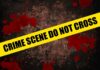 Yellow caution tape reading 'CRIME SCENE DO NOT CROSS' over a dark, blood-splattered background
