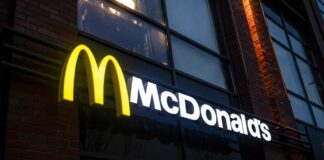 Illuminated McDonald's sign on a brick building at night