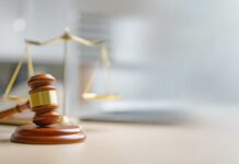 Judge TORPEDOES Trump’s Lawsuit A wooden gavel and scales of justice on a desk