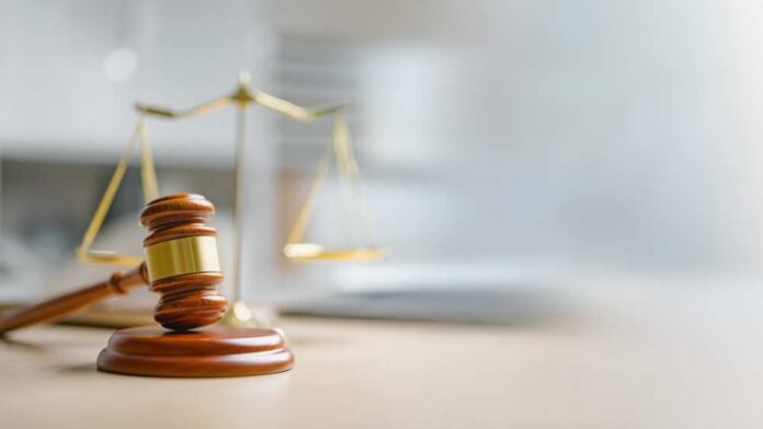 shutterstock_2666716167.jpg A wooden gavel and scales of justice on a desk