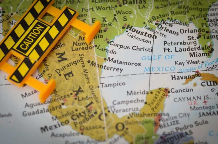 A caution sign placed on a map highlighting Mexico and the Gulf of Mexico