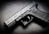Black Glock 19 pistol on a dark surface.