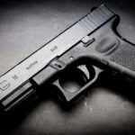 Black Glock 19 pistol on a dark surface.