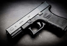 Black Glock 19 pistol on a dark surface.