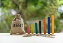Awful Debt Milestone Reached as Prices SKYROCKET Debt sack with rising financial graph bars.