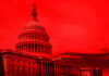 United States Capitol building under red-tinted sky.
