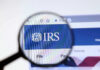 Magnifying glass focusing on IRS website logo.