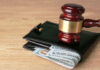 Gavel on wallet with visible dollar bills