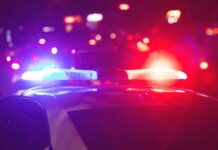 Curfew Crackdown: Teens Targeted Police officer and vehicle with flashing lights.