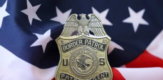 Border Patrol badge resting on an American flag