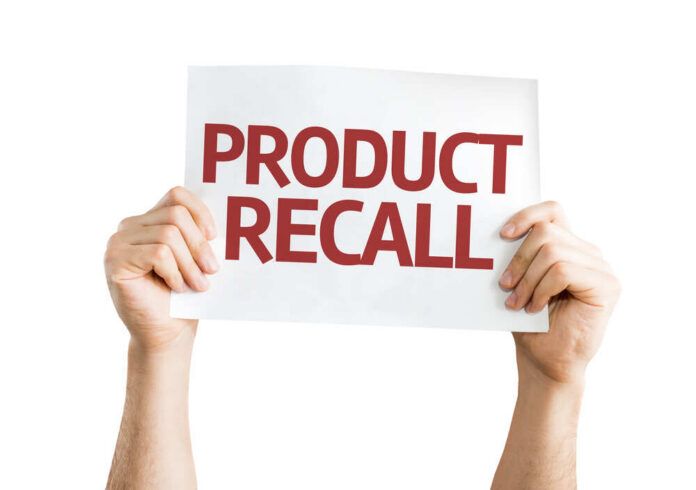 shutterstock_251746651.jpg Hands holding a sign that reads 'PRODUCT RECALL'
