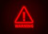 Red neon warning sign with an exclamation mark