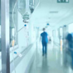 Ebola ALERT: Dangerous Strain Crosses Border! Hospital corridor with IV drip and healthcare worker.