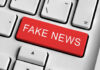 Close-up of a keyboard with a prominent red key labeled 'FAKE NEWS'