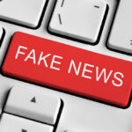 Close-up of a keyboard with a prominent red key labeled 'FAKE NEWS'