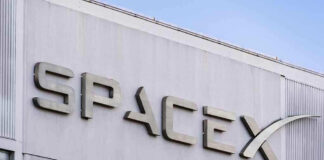 SpaceX building logo against blue sky.
