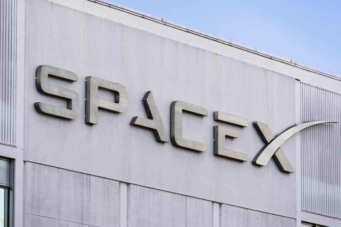 1589390272 SpaceX building logo against blue sky.