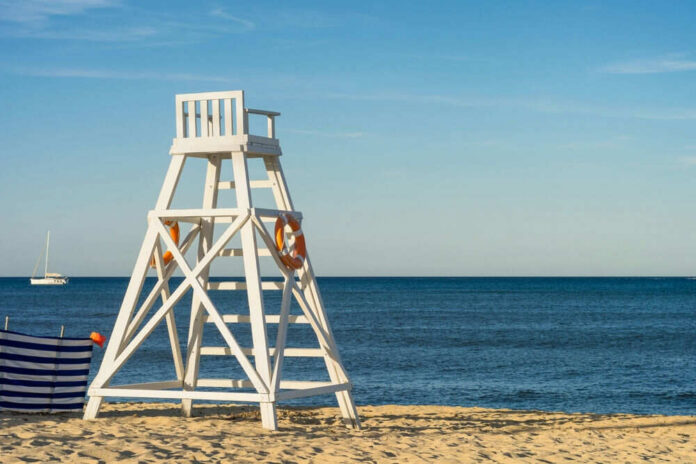 Lifeguard chair on sandy beach near ocean