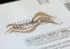 Judge Slams Voter Purge Machine Official election mail envelope with postal service markings