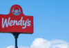 Wendy's restaurant sign against a clear blue sky