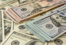 Stacks of US dollars featuring Benjamin Franklin and Ulysses S. Grant.