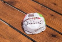 A wrapped Whopper Jr. burger resting on a wooden table