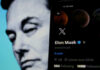 Elon Musks profile on mobile screen, blurred background face.