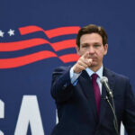 DeSantis Calls It Victory Even As It Closes Governor of Florida, Ron DeSantis points forward at podium.