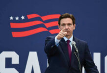 DeSantis Calls It Victory Even As It Closes Governor of Florida, Ron DeSantis points forward at podium.