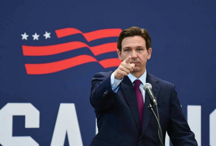shutterstock_2352132667 Governor of Florida, Ron DeSantis points forward at podium.