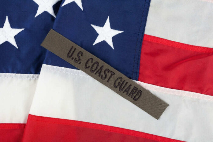 shutterstock_2492733653 U.S. Coast Guard patch on American flag.