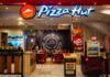 Pizza Titan Ditches Hut — Why Now? Illuminated Pizza Hut sign on a dark background