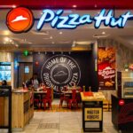 Illuminated Pizza Hut sign on a dark background